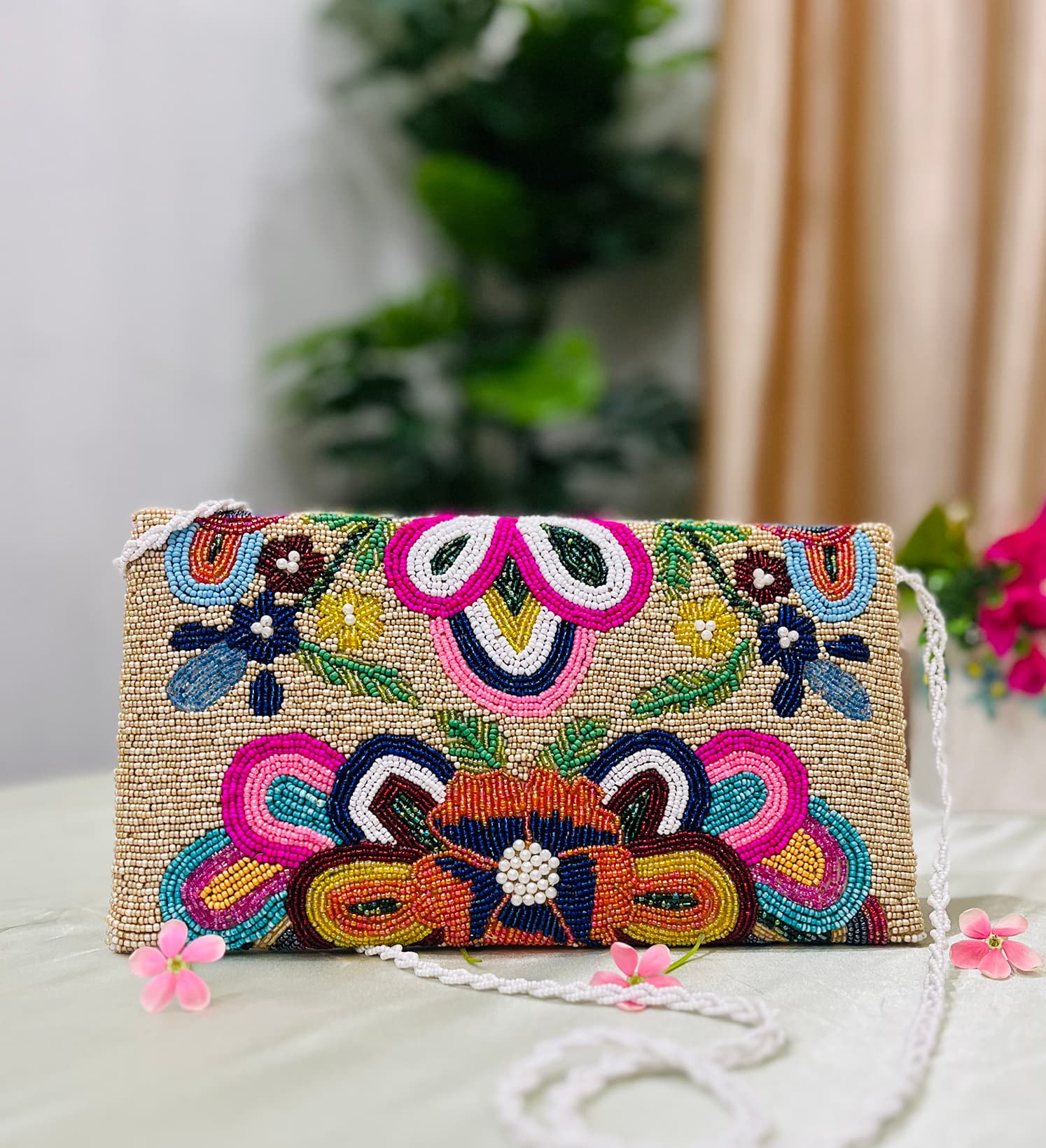 Colorful floral-themed beaded envelope clutch showcasing intricate beadwork by Zara, against a plain background.
