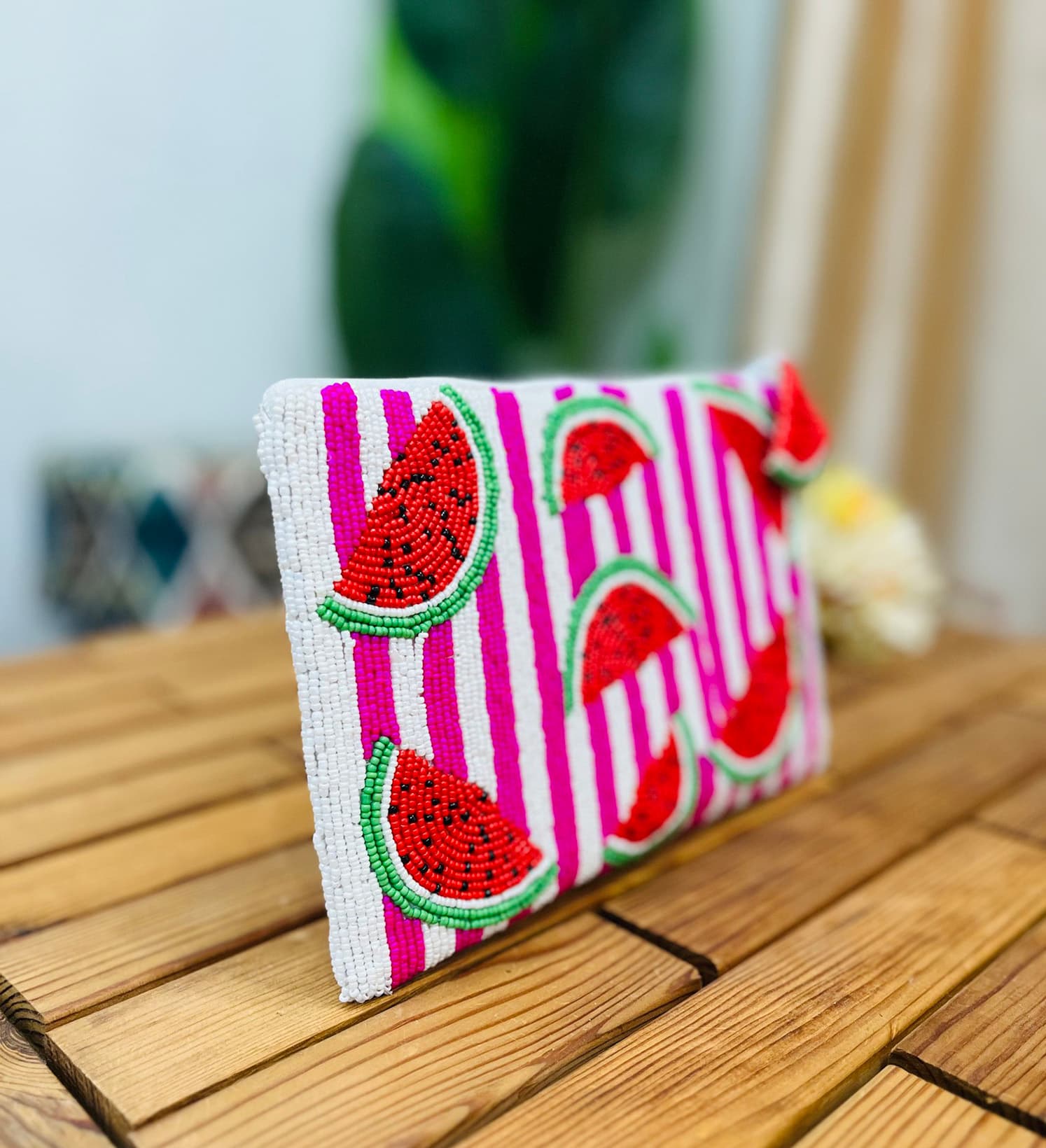 A colorful hand-beaded fabric pouch featuring a watermelon motif, displaying intricate patterns and vibrant colors.